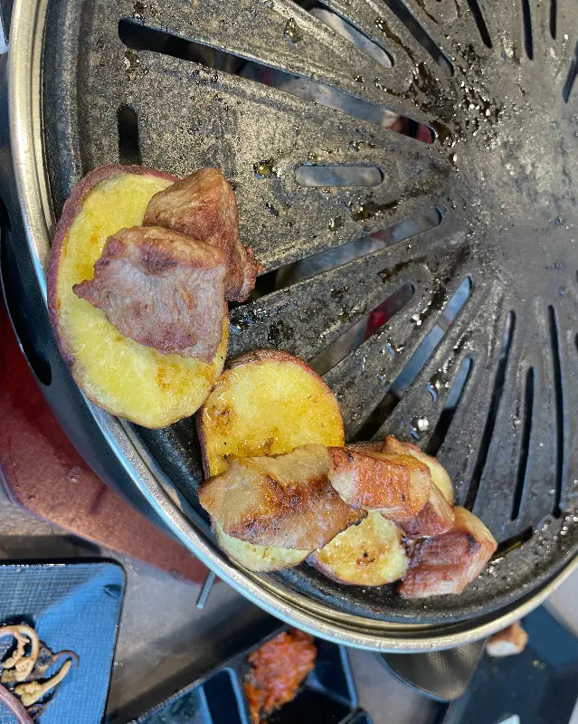 불판 위에서 익어가는 고기와 고구마