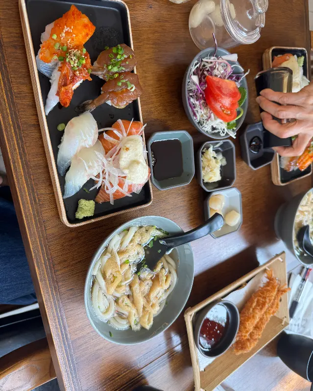 식탁 가득 차려진 초밥과 곁들임 음식