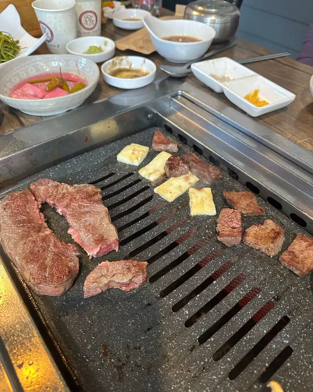 불판 위에서 맛있게 구워지는 소고기와 치즈