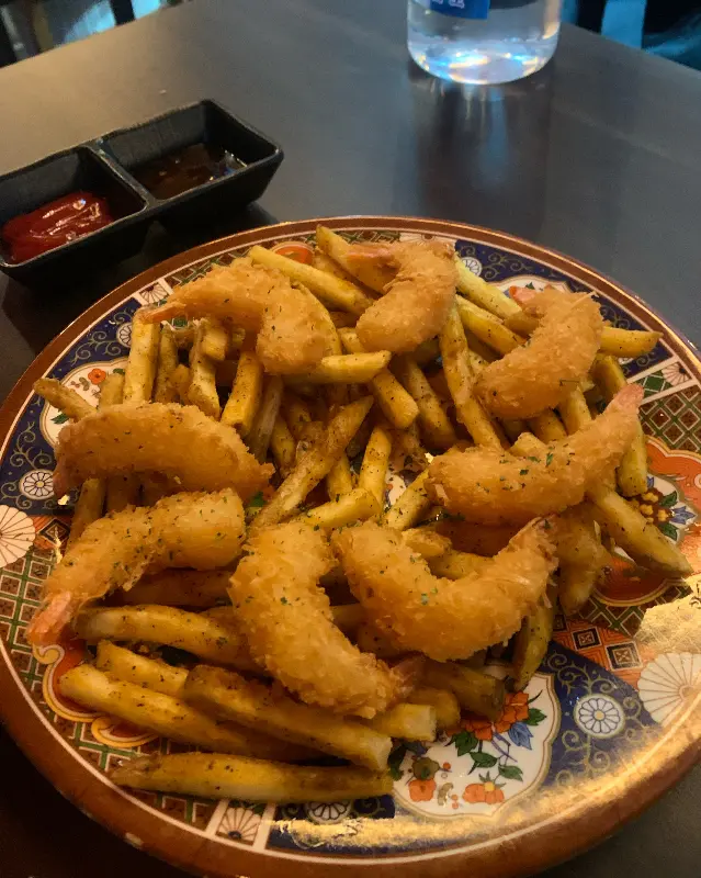 접시에 담긴 감자튀김과 새우튀김 사진