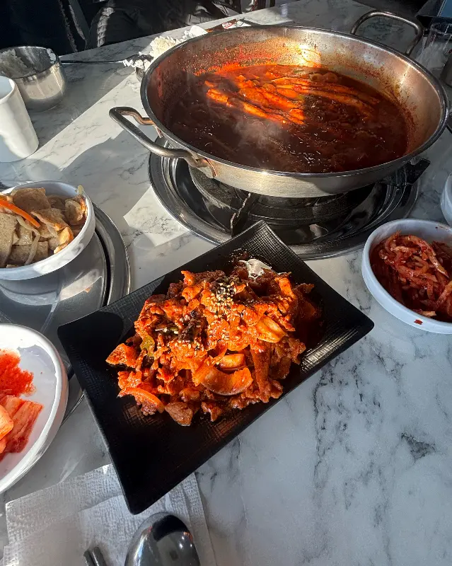 갈치조림, 제육볶음, 밑반찬이 차려진 테이블