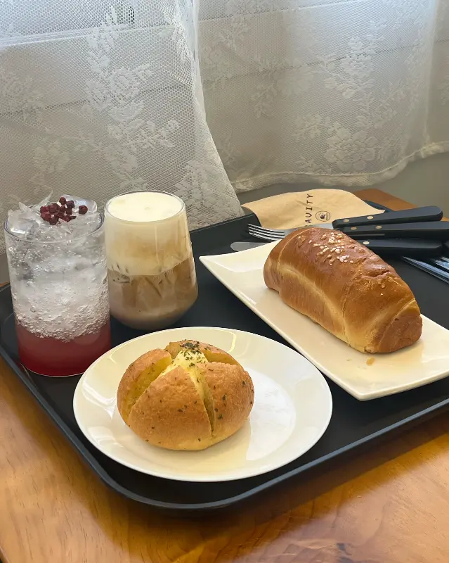 자두에이드와 라떼, 빵이 함께 놓인 쟁반