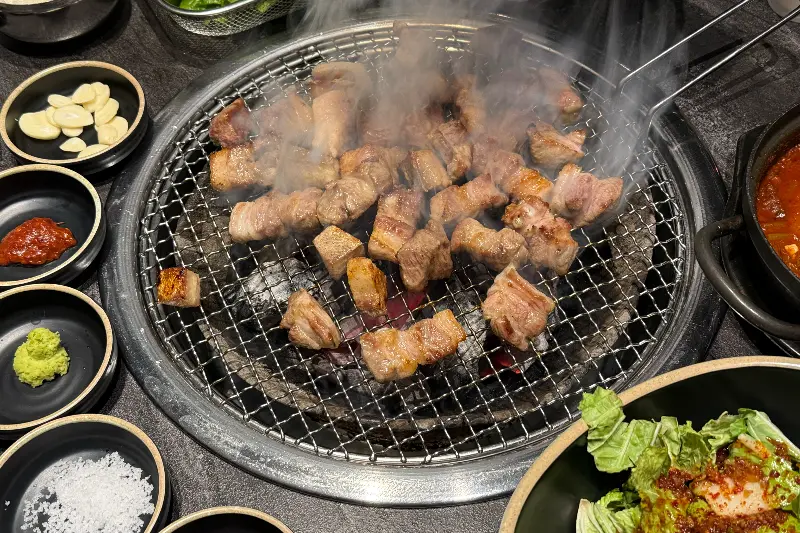 숯불 위에서 노릇하게 구워지고 있는 흑돼지