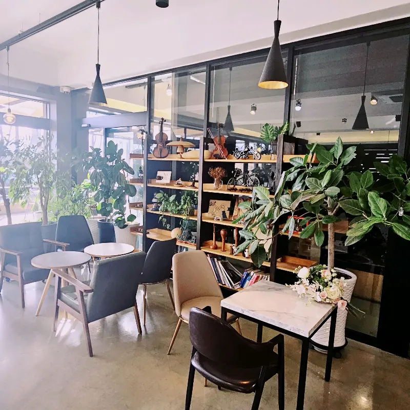 카페 내부, 책장과 테이블이 조화롭게 배치되어 있다.