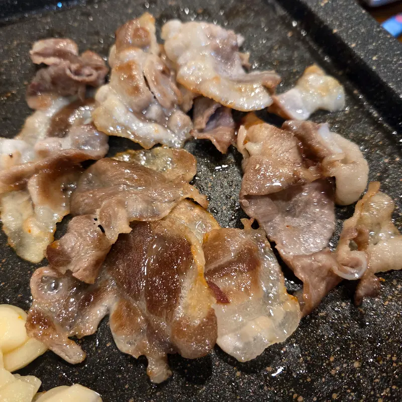 불판 위에서 노릇하게 익어가는 대패 삼겹살