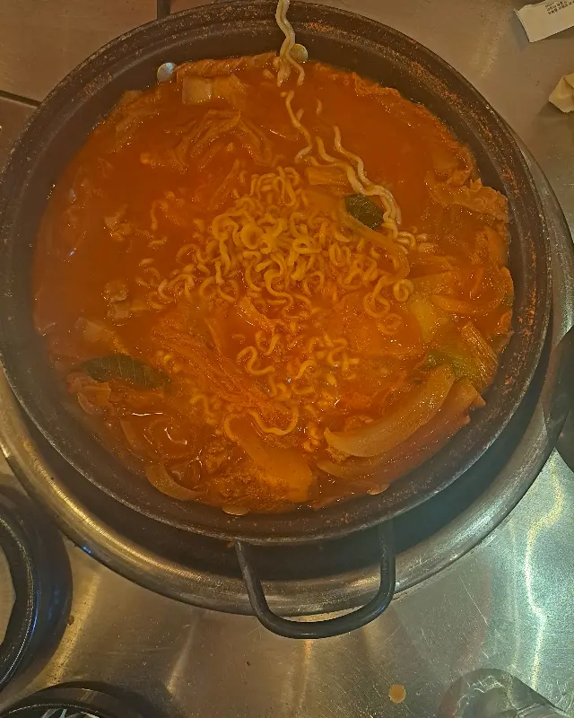 김치찌개에 라면 사리가 추가된 모습