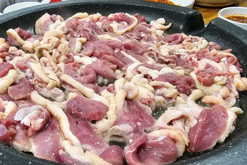 불판 위에 올려진 신선한 오리 로스