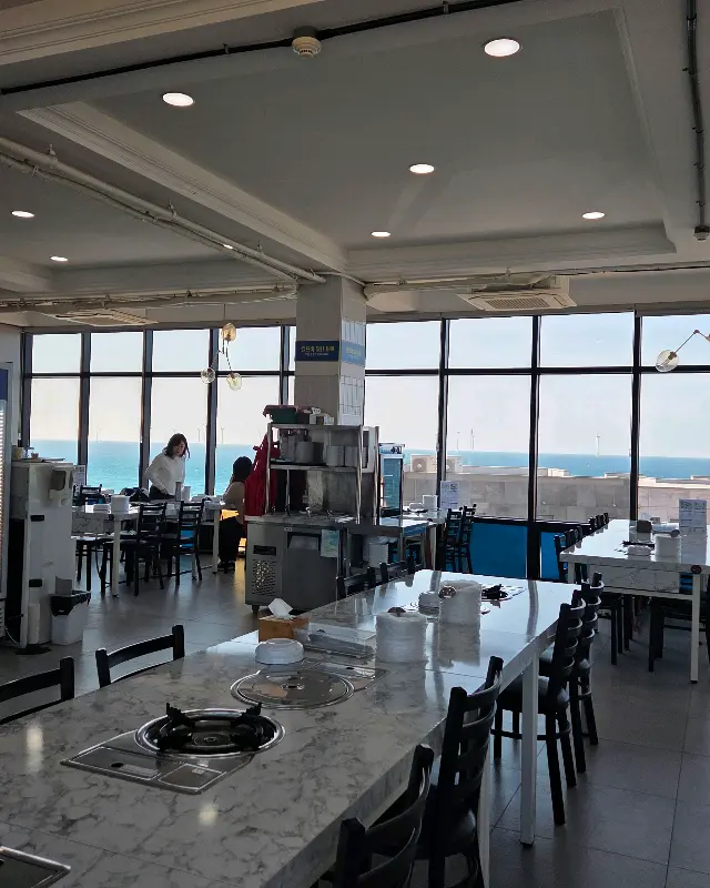 넓은 창으로 바다가 보이는 제주해도미락 내부