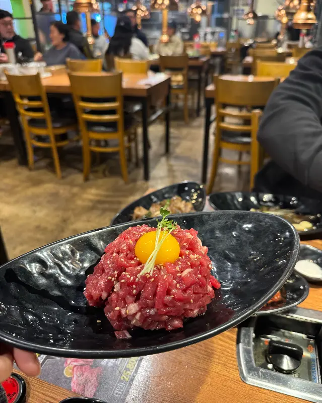 육회가 담긴 검은색 접시