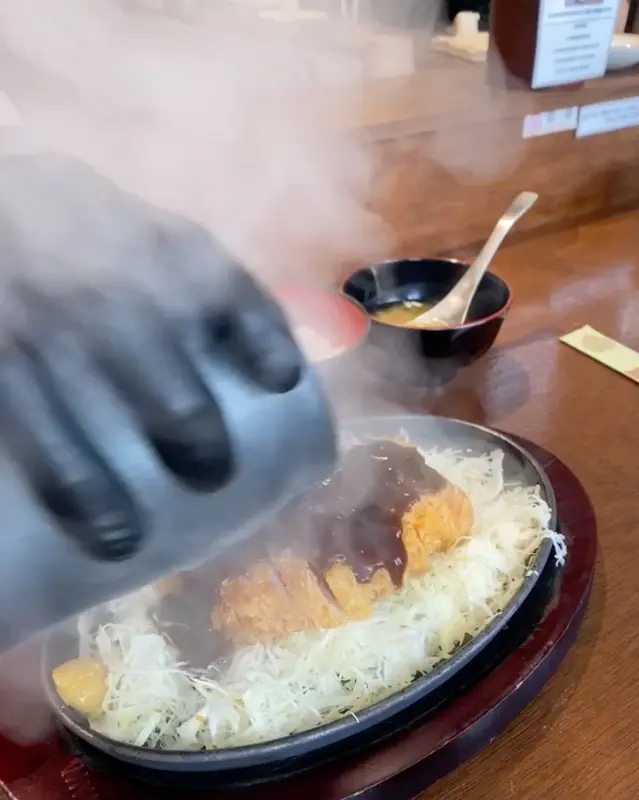 미소철판카츠에 소스 뿌리는 모습