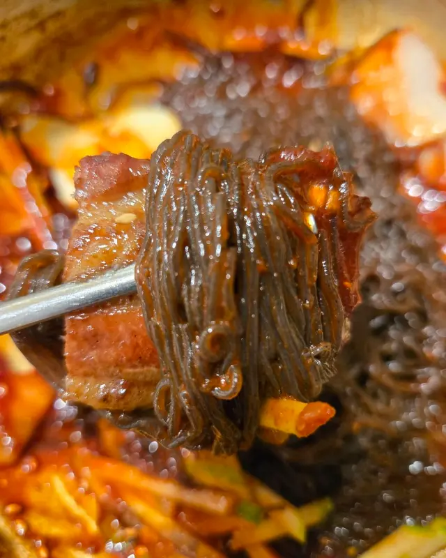 젓가락으로 집어 올린 비빔냉면의 면발이 윤기가 흐르고 있다.