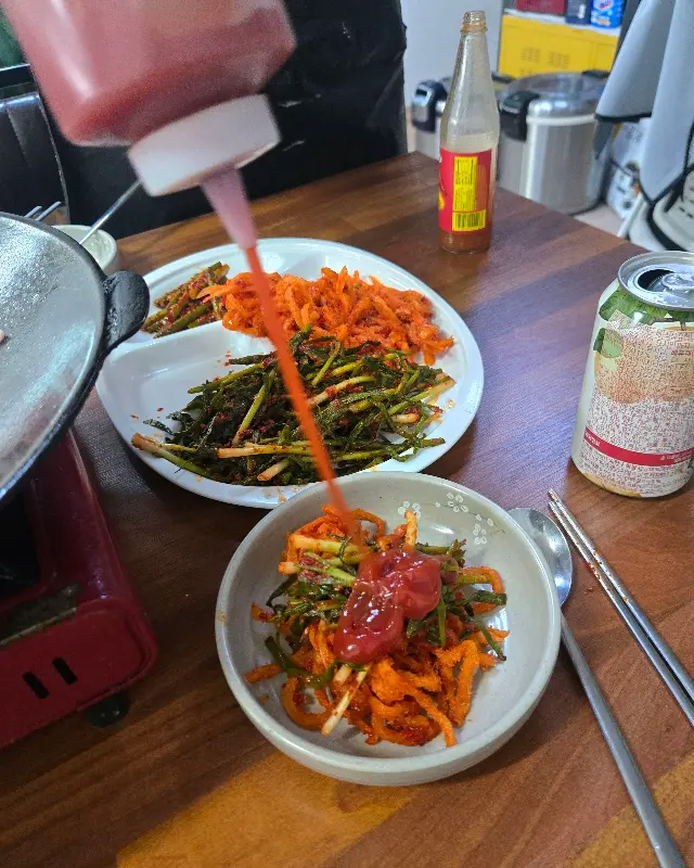 무생채와 파김치에 소스 뿌리는 모습