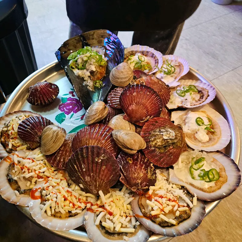 알록달록한 토핑이 올려진 싱싱한 조개구이