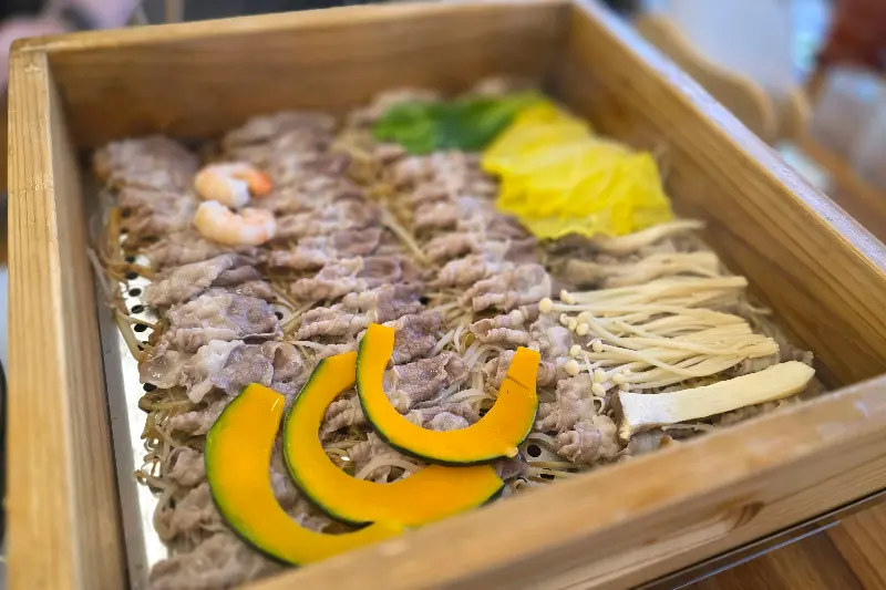 편백찜의 아름다운 비주얼. 얇게 썰린 소고기와 신선한 야채가 조화롭게 담겨 있다.