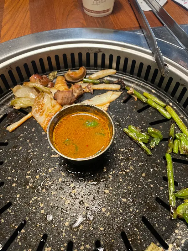 다 구워진 고기와 채소가 불판 위에 놓여 있는 모습