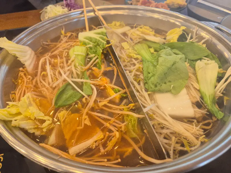 샤브샤브 냄비 안에서 채소와 면이 끓고 있는 모습