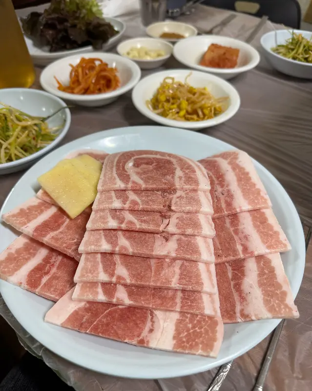 푸짐한 밑반찬과 냉동 삼겹살