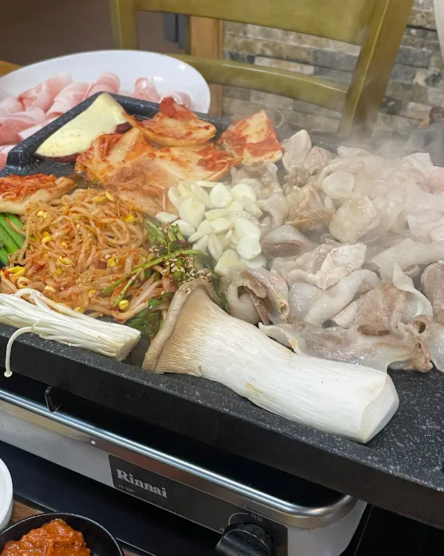 불판 가득 구워진 대패 삼겹살과 김치
