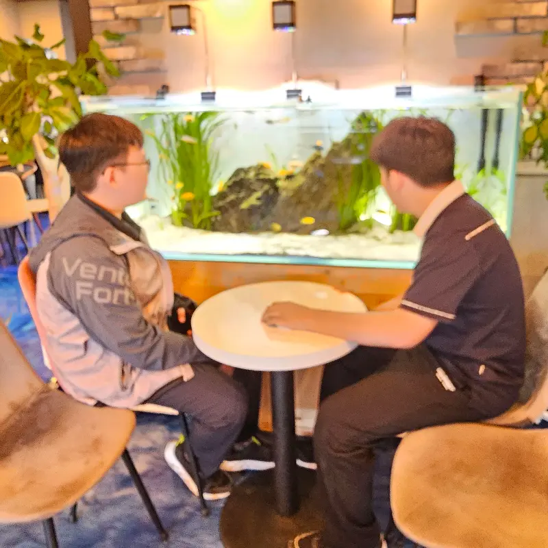 수조 앞에서 대화하는 사람들