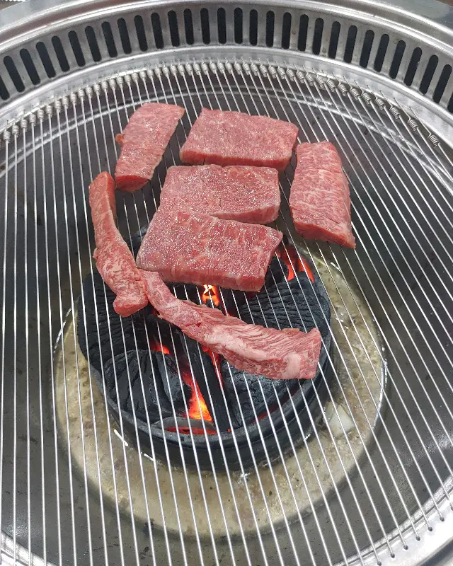 숯불 위에서 구워지고 있는 소고기 사진