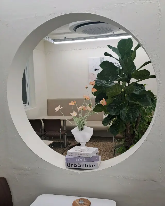 원형 창문 옆 테이블에 놓인 음료와 디저트