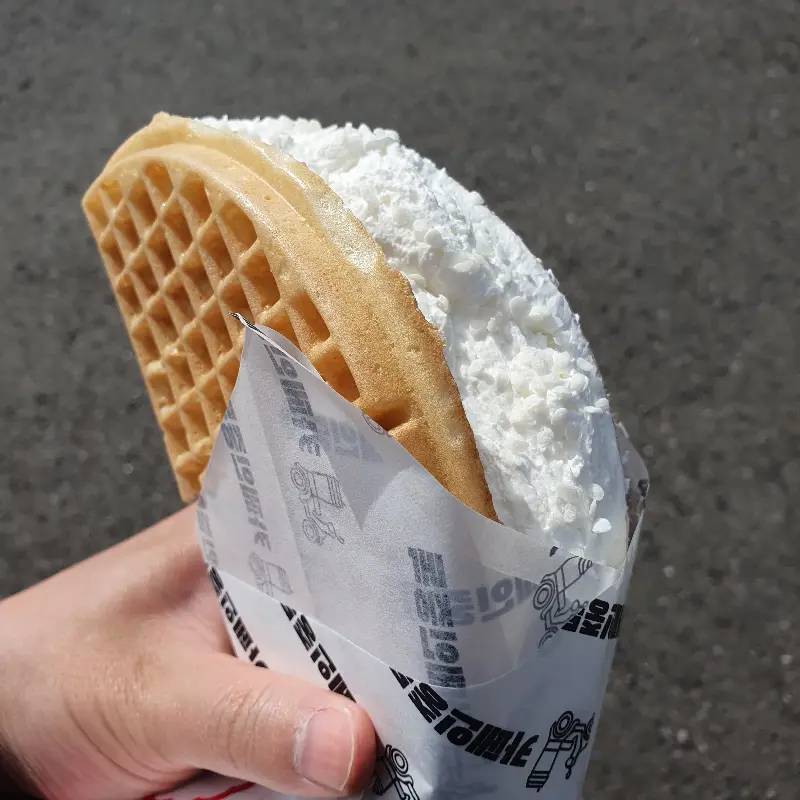 눈처럼 하얀 크림이 덮인 와플