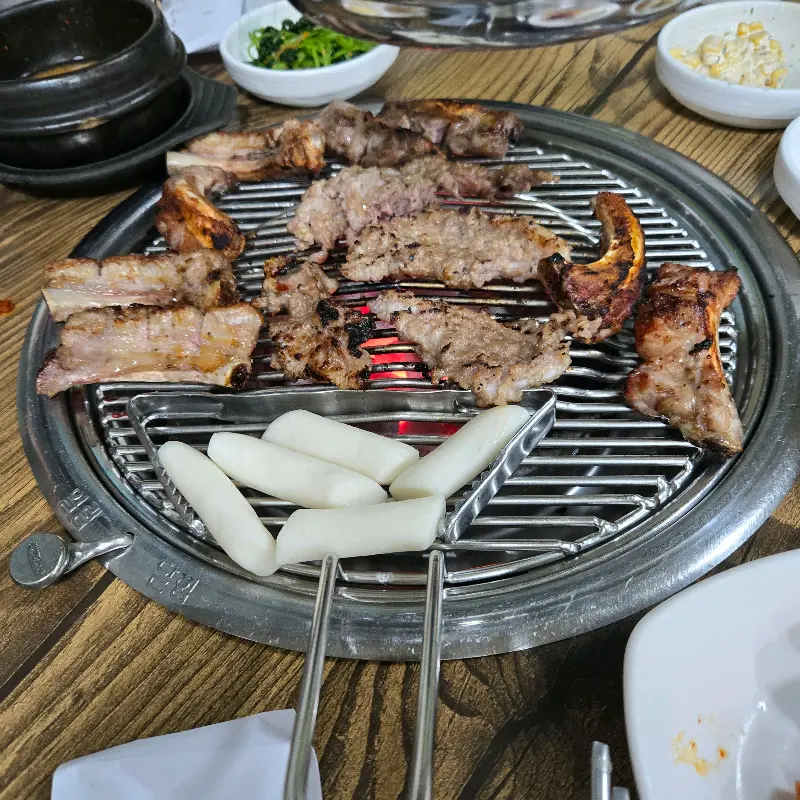 숯불 위에서 맛있게 익어가는 쪽갈비와 떡