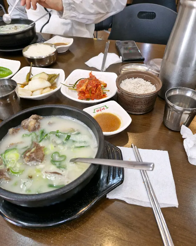 테이블 위에 놓인 곰탕과 반찬들