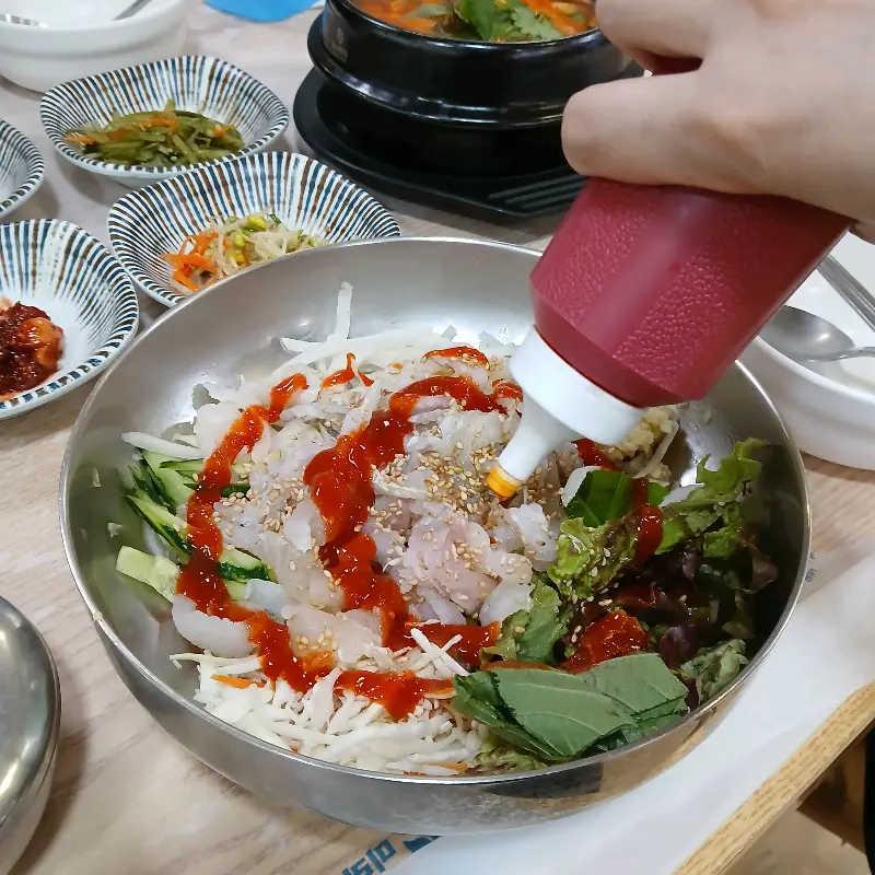 물회에 초장을 뿌리는 모습