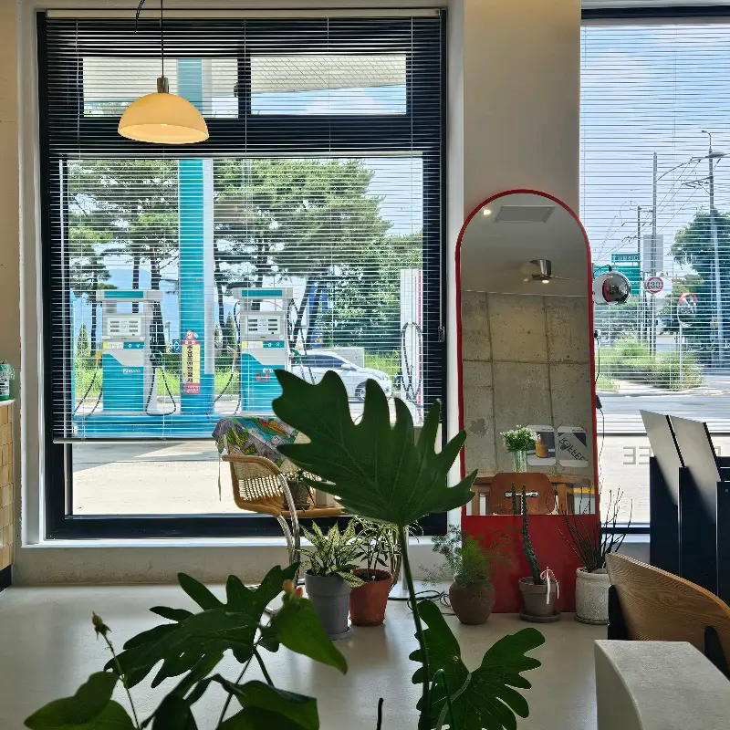 카페 ROFFEE의 통유리창 너머 보이는 주유소 풍경