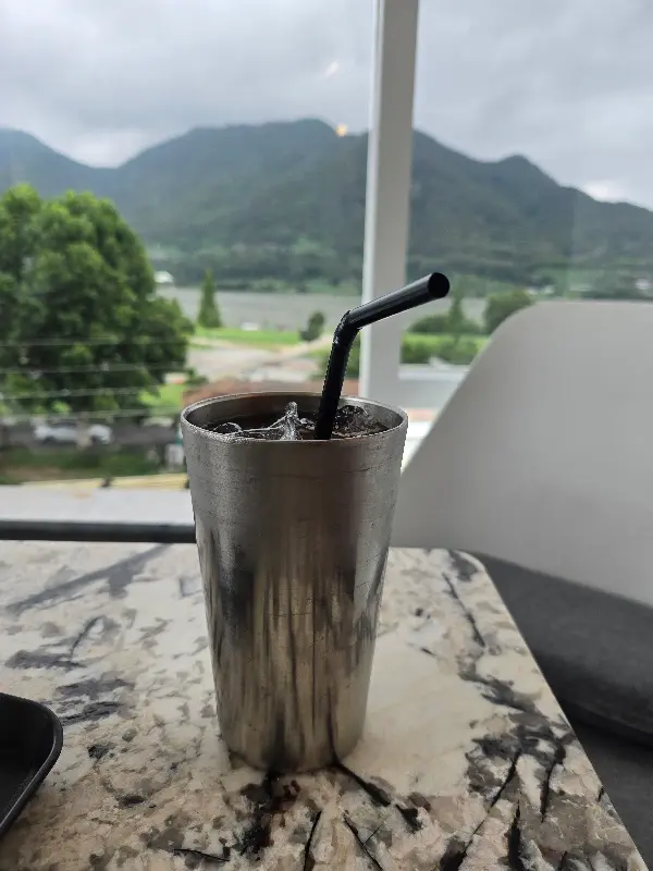 창밖으로 보이는 산과 강의 풍경 사진. 아름다운 자연 경관을 자랑한다.