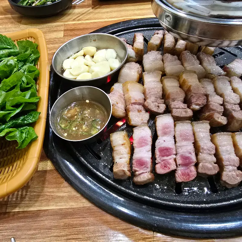 초벌된 오겹살이 숯불 위에서 맛있게 구워지는 모습