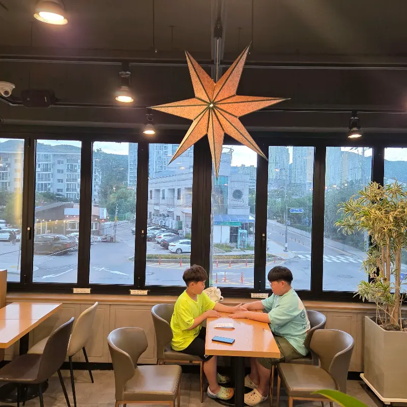 창밖 풍경을 바라보며 빙수를 즐기는 사람들