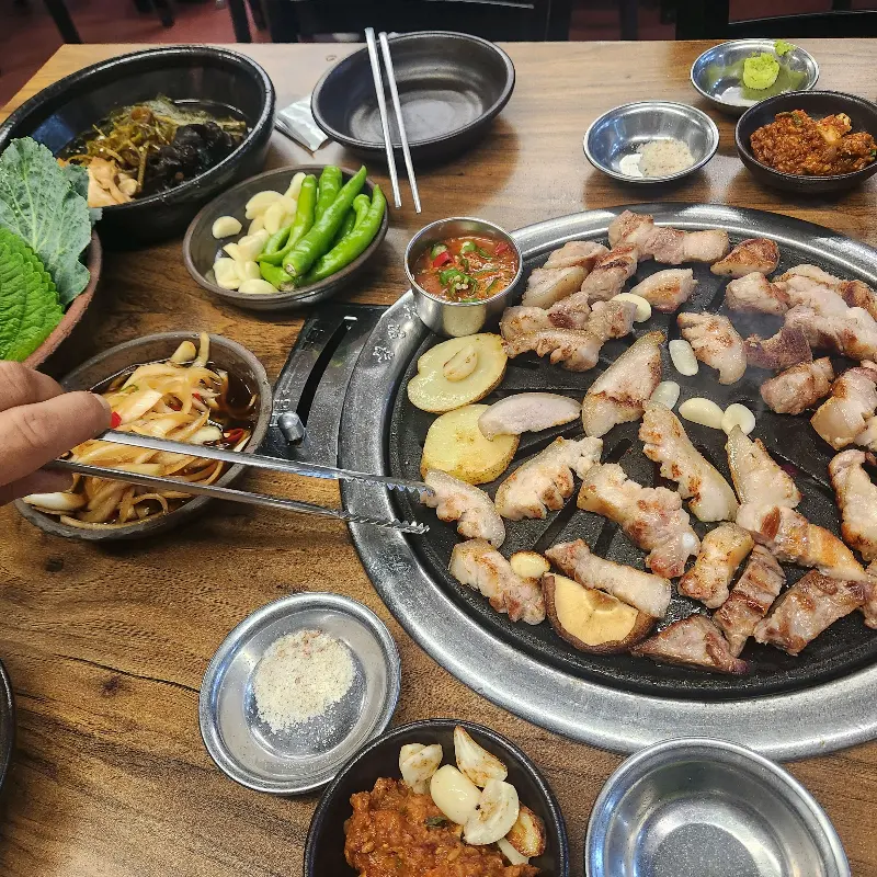 숯불에 구워지는 오겹살과 풍성한 밑반찬