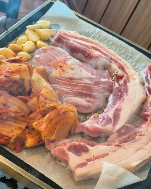 오겹살과 김치를 함께 구워 먹는 모습