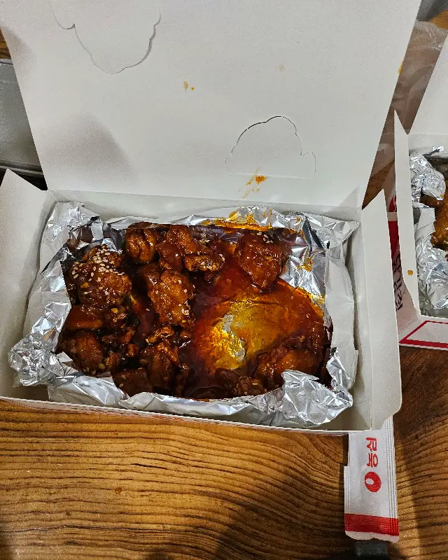 포장 상자 안, 은박지에 담긴 윤기 좔좔 흐르는 닭강정