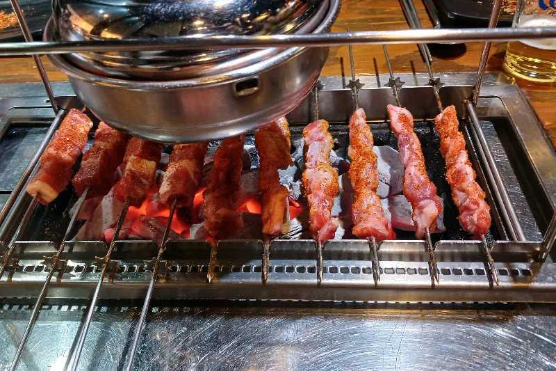 숯불 위에서 익어가는 다양한 꼬치들