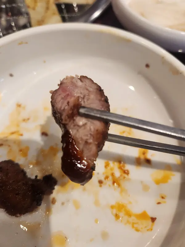 젓가락으로 집어올린 쪽갈비 단면