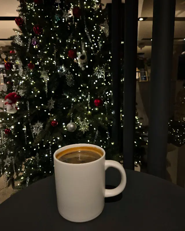 머그잔에 담긴 커피와 크리스마스 트리