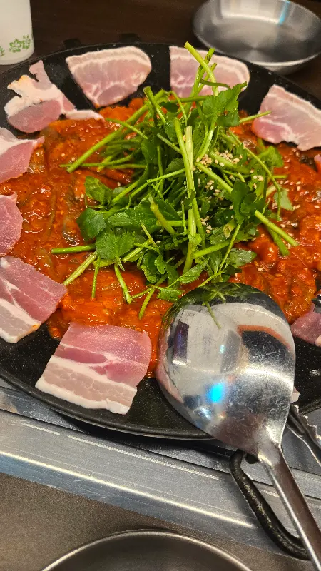 불판 위에서 맛있게 익어가는 쭈꾸미와 삼겹살