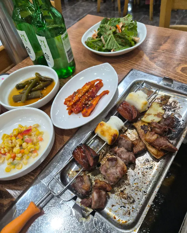 잘 구워진 오리 꼬치 구이와 밑반찬