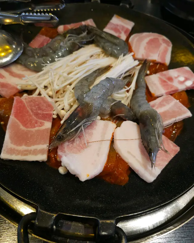 쭈꾸미 삼겹살에 콘치즈를 곁들여 먹는 모습