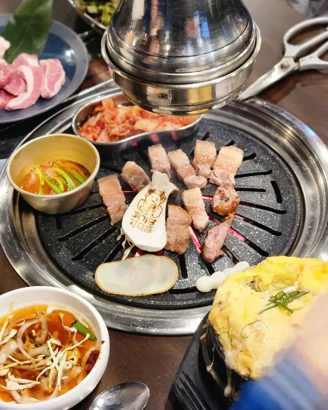 고기왕 김육즙 불판 위의 삼겹살과 김치, 계란찜