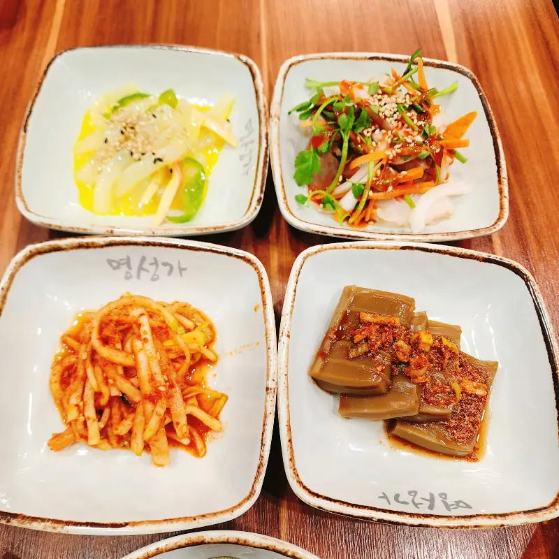 정갈하게 담겨 나온 밑반찬들. 샐러드, 묵, 김치 등 종류가 다양하다.