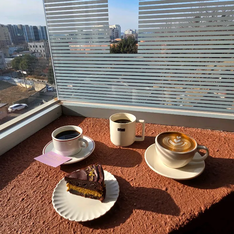 커피와 케이크가 놓인 창가 테이블