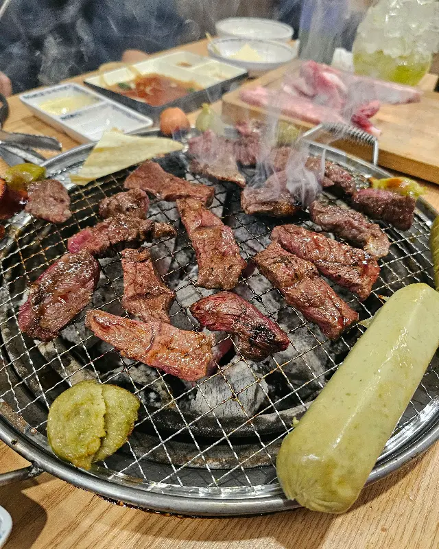 숯불 위에서 맛있게 구워진 다양한 부위의 소고기