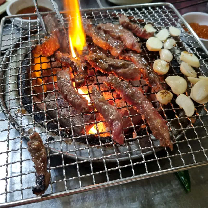 숯불 화로 위에서 노릇하게 구워지는 소갈비살