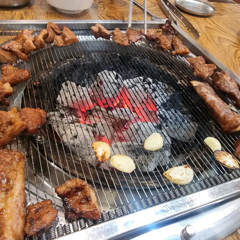 숯불 위에서 익어가는 돼지갈비와 마늘