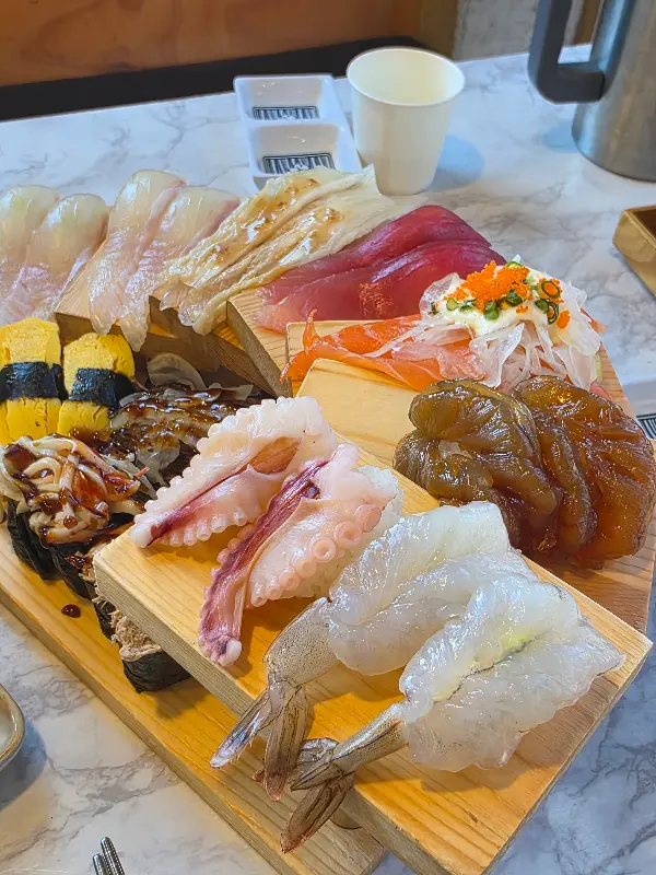 나무 도마 위에 올려진 다양한 종류의 신선한 초밥들