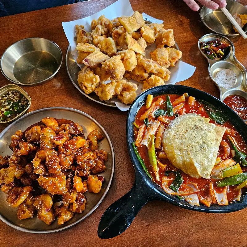 푸짐하게 차려진 치킨, 닭똥집, 떡볶이 한 상